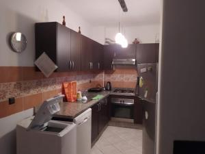 eine kleine Küche mit braunen Schränken und einem Kühlschrank in der Unterkunft Cabo dream in Tétouan