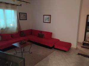ein Wohnzimmer mit einem roten Sofa und einem Tisch in der Unterkunft Cabo dream in Tétouan