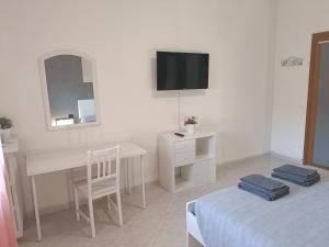 Camera bianca con scrivania e TV di Sofia Sweet Home a Corsico