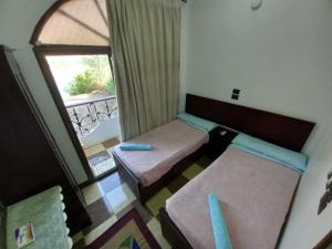 Habitación pequeña con 2 camas y ventana en BAYT ZAINA - Nubian hospitality house en Asuán
