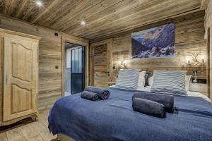 1 dormitorio con 1 cama azul grande y paredes de madera en Chalet Chèvrefeuille en Saint-Gervais-les-Bains