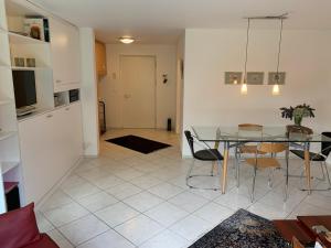 eine Küche und ein Esszimmer mit einem Glastisch und Stühlen in der Unterkunft Apartment Flims Waldhaus - Surselvapark A4 in Flims