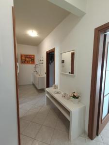 ein Badezimmer mit einem weißen Tisch und einem Waschbecken in der Unterkunft Sofia Sweet Home in Corsico
