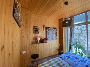 1 dormitorio con 1 cama y pared de madera en CAN LLUNA Tú casa zen, en Tàrbena