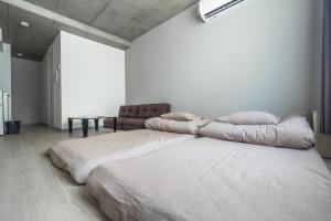 ein weißes Schlafzimmer mit 2 Betten und einem Tisch in der Unterkunft Marvelous Koiwa - Vacation STAY 90651v in Tokio