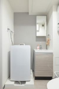 W białej łazience znajduje się umywalka i lustro. w obiekcie Marvelous Koiwa - Vacation STAY 90651v w Tokio