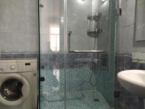 ein Badezimmer mit einer Waschmaschine und einem Waschbecken in der Unterkunft KOSHGARI APARTMENT in Samarkand