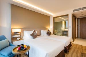 Postel nebo postele na pokoji v ubytování Comodo Nha Trang Hotel