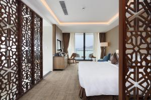 Postel nebo postele na pokoji v ubytování Comodo Nha Trang Hotel