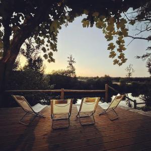 drie stoelen op een terras met uitzicht op een meer bij Casa do Rio Alva in Arganil