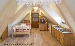 eine Küche im Dachgeschoss mit Kinderbett in einem Zimmer in der Unterkunft Sonnenhaus Grandl in Feldbach