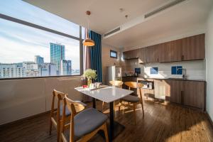 a kitchen with a table and chairs and a large window at Aaron Hotel in Nha Trang