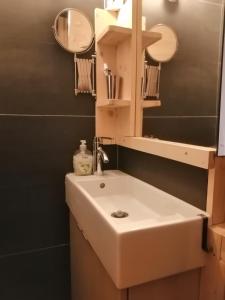 y baño con lavabo blanco y espejo. en Appartement de 28 m2, centre station les 2 alpes, en Les Deux Alpes