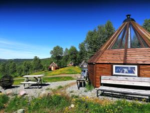 uma cabana de madeira com uma mesa de piquenique e um banco de piquenique em Hessdalen Ufocamp em Vårhus