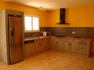 a kitchen with yellow walls and a sink and a refrigerator at VILLA 4pers, STUNNING SEA VIEW, BEACH ON FOOT 4* in Olmeto