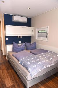 um quarto com uma cama grande e almofadas roxas em Hausboote am Bärwalder See Traumhaus-mieten em Klitten