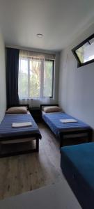 um quarto com duas camas e uma janela em Guest house Garden Beach em Batumi