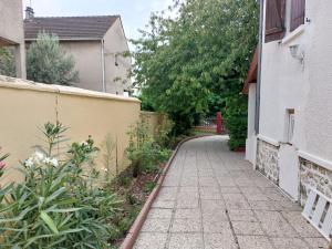 an alley way in a house with a building and trees at Happy Land Holliday residential in Épinay-sur-Seine