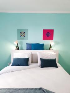 um quarto com uma cama branca e paredes azuis em Dimore Italiane - Boutique Apartments em Corralejo