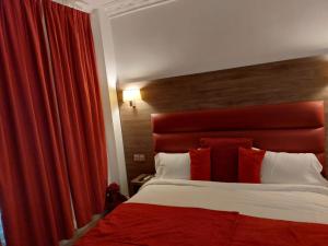 um quarto com uma cama grande e uma cabeceira vermelha em Happy Land Holliday residential em Épinay-sur-Seine