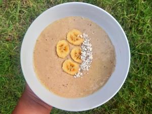 a person holding a bowl of oatmeal with bananas in it at Vista Huts Lembongan in Nusa Lembongan