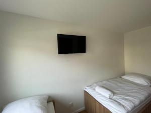 a room with two beds and a tv on the wall at Apartmotel ANROE in Chminianska Nová Ves