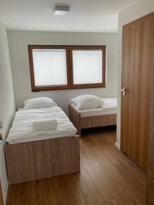 a bedroom with two beds and a window at Apartmotel ANROE in Chminianska Nová Ves