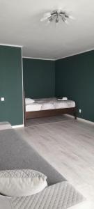 a bedroom with a bed with a green wall at Изумруд in Uralsk +2 photos