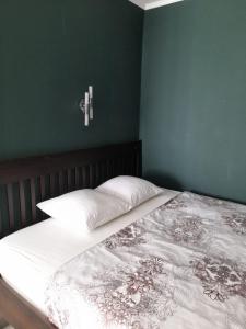 a bedroom with a bed with a cross on the wall at Изумруд in Uralsk