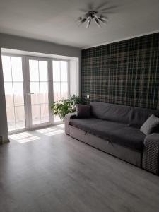uma sala de estar com um sofá e uma grande janela em Изумруд em Oral