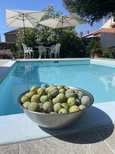 a bowl of fruit sitting next to a swimming pool at Casa do Beco B&B Douro - Guest House in Parambos