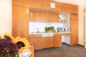 a kitchen with wooden cabinets and a kitchen with a sunflower at acora Leipzig Living the City in Leipzig