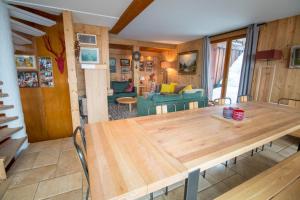 una sala da pranzo e un soggiorno con un tavolo in legno di Chalet King's Hame a Méribel