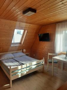 コンティ・リバツキエにあるSiedlisko na Zaciszu domekの木造キャビン内のベッド1台が備わるベッドルーム1室を利用します。