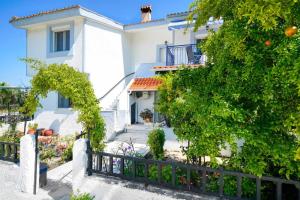 a white house with a fence in front of it at yiayia and papou Luxury House in Limenas