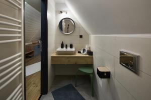 a bathroom with a sink and a mirror at Zöld Béka Vendégház in Komló