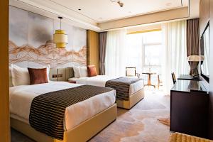 una camera d'albergo con due letti e una televisione di LDS Hotel Belgrade a Belgrado
