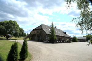 a large wooden barn sitting on top of a road at Aida Apartment in Külitse