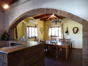 cocina y comedor con mesa y sillas en Tree House Hostel en Salto de las Rosas
