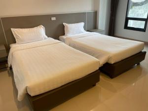 にあるSinsiri hostelのベッド2台が隣同士に設置された部屋です。