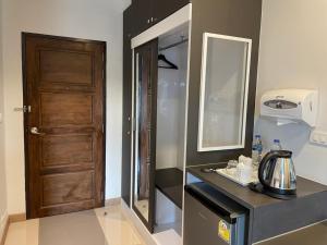 a kitchen with a refrigerator and a wooden door at Sinsiri hostel in Ban Ku
