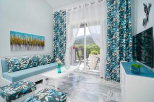a living room with a couch and a table and a window at yiayia and papou Luxury House in Limenas