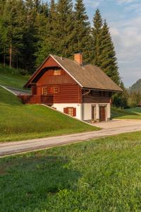 a large wooden house on a hill with a road at Chalet Ajda in Bohinj