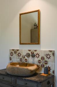 a bathroom with a stone sink and a mirror at La Bastide Neuve in Joucas