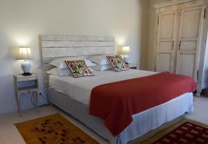 La Bastide Neuve في جوكاس: غرفة نوم بسرير كبير مع بطانية حمراء