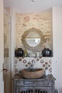 uma casa de banho com um lavatório e um espelho na parede em La Bastide Neuve em Joucas