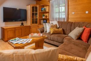 a living room with a couch and a tv at Chalet Ajda in Bohinj
