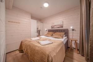 a bedroom with a bed with two towels on it at Levillas Sointuilevi 1 B67, 2 ski pass included in Levi