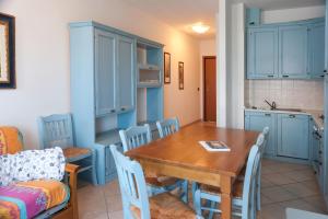 a kitchen and dining room with a wooden table and chairs at Le Residenze di Santa Costanza - Mirto/Corbezzolo in San Vincenzo