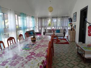 ein Wohnzimmer mit einem Tisch und einem Sofa in der Unterkunft Petite fleur de lentilles in Cilaos